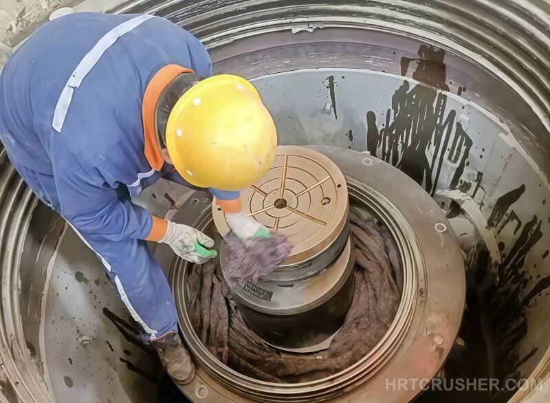 Cleaning thrust plate surface to remove debris before installation in Metso Nordberg HP500